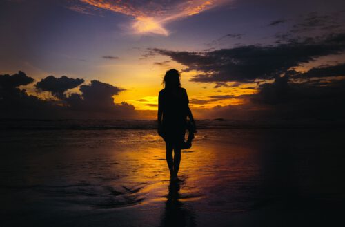 Frau am Meer zum Sonnenuntergang