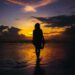 Frau am Meer zum Sonnenuntergang